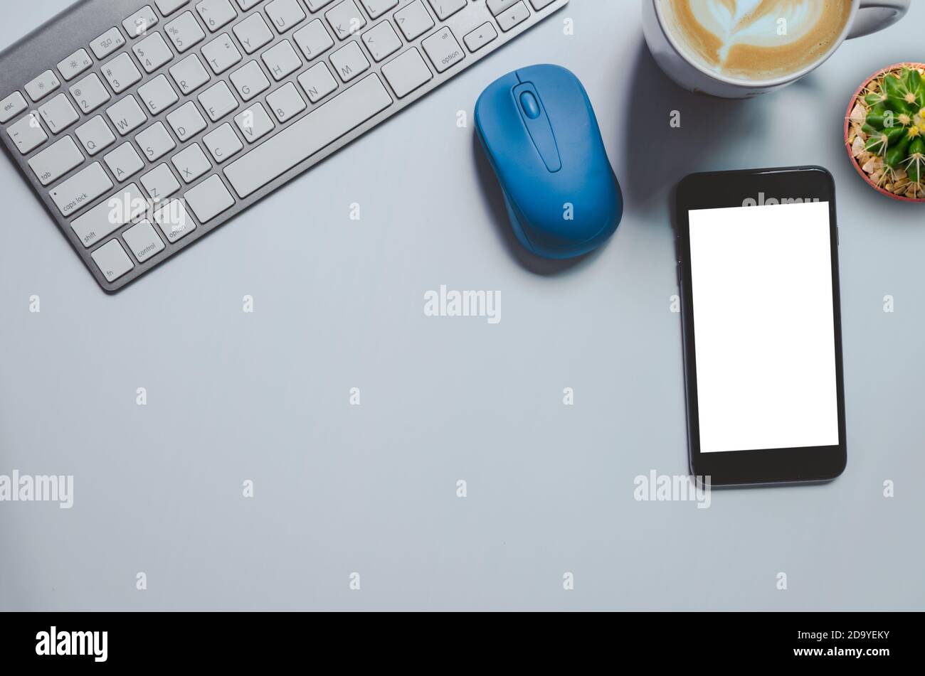 Top view mockup smartphone  , keyboard, coffee mug and cactus on background.copy space Stock Photo