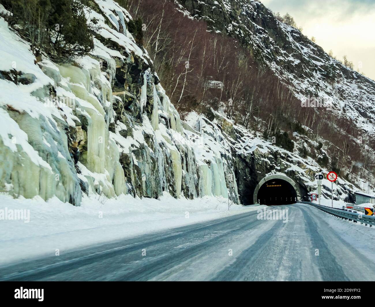 Frozen iced waterfalls and dark tunnel in the mountains and streets of Norway. Stock Photo