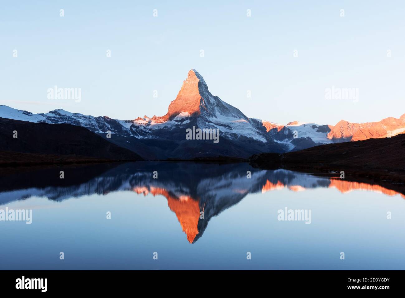 Picturesque landscape with colorful sunrise on Stellisee lake. Snowy Matterhorn Cervino peak with reflection in clear water. Zermatt, Swiss Alps Stock Photo