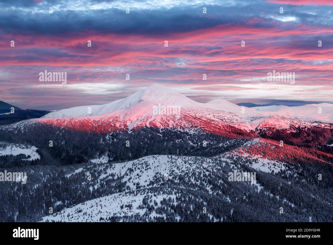 Fantastic orange winter landscape in snowy mountains glowing by sunlight. Dramatic wintry scene with snowy trees. Christmas holiday background Stock Photo