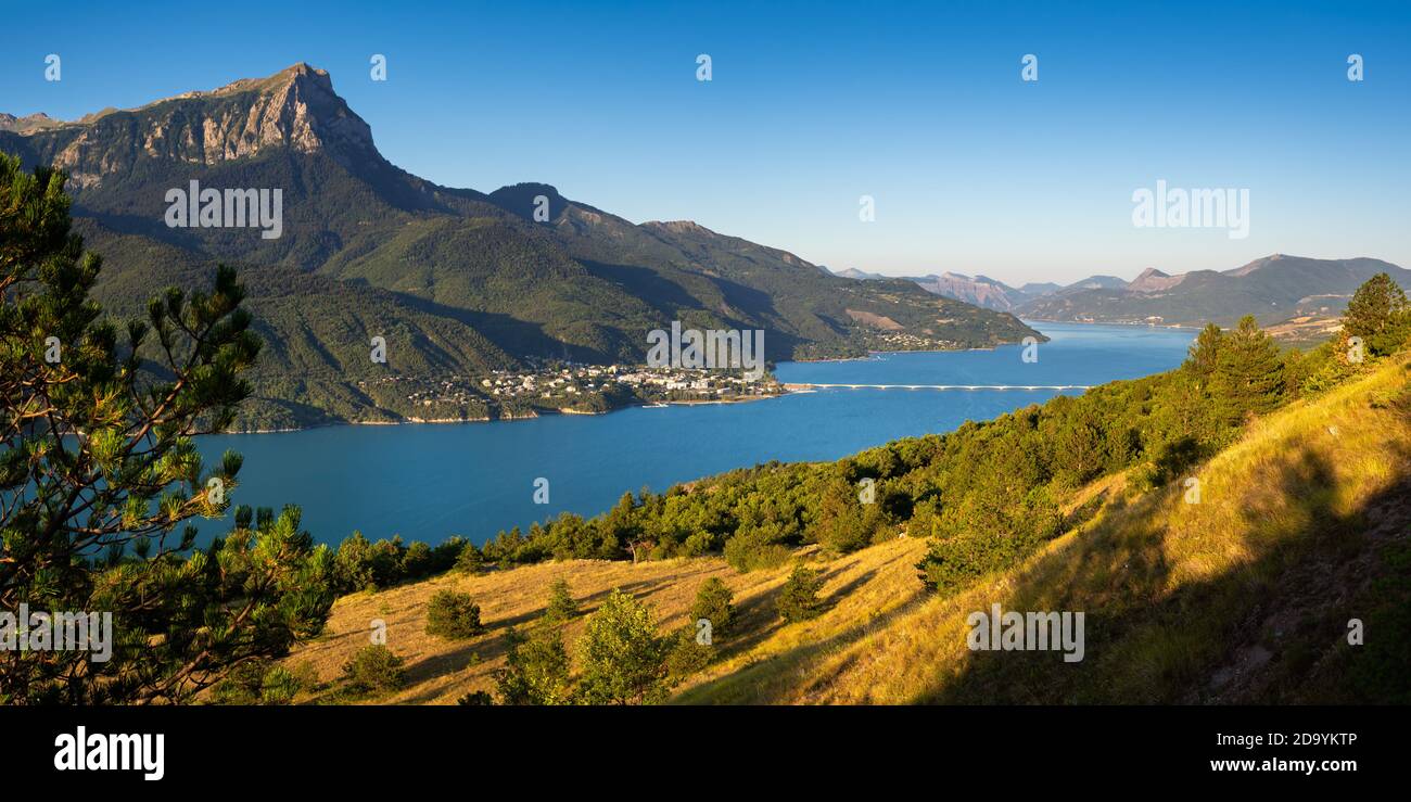 The village of Savines-le-Lac with its bridge and the Grand-Morgon mountain peak in Summer along the Serre-Poncon lake. Hautes-Alpes, Alps, France Stock Photo