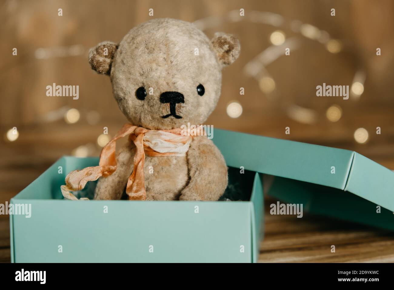 Sitting teddy bear in a gift box on a blurred wooden background. Gifts and  surprises for any occasion. Selective focus. Copy space Stock Photo - Alamy