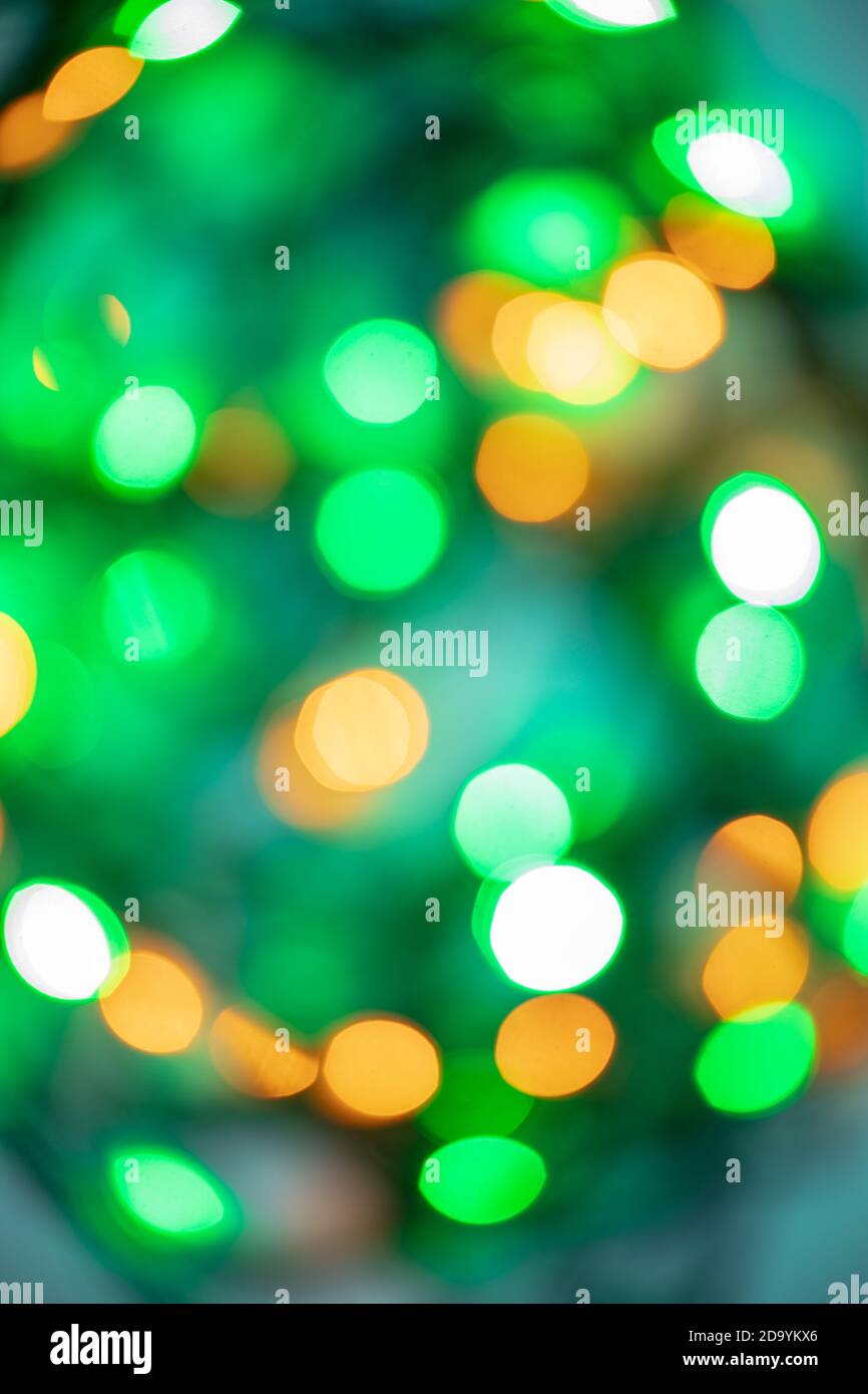 abstract bokeh background of evening festive lights in green, yellow and orange round shape lights. Christmas concept Stock Photo