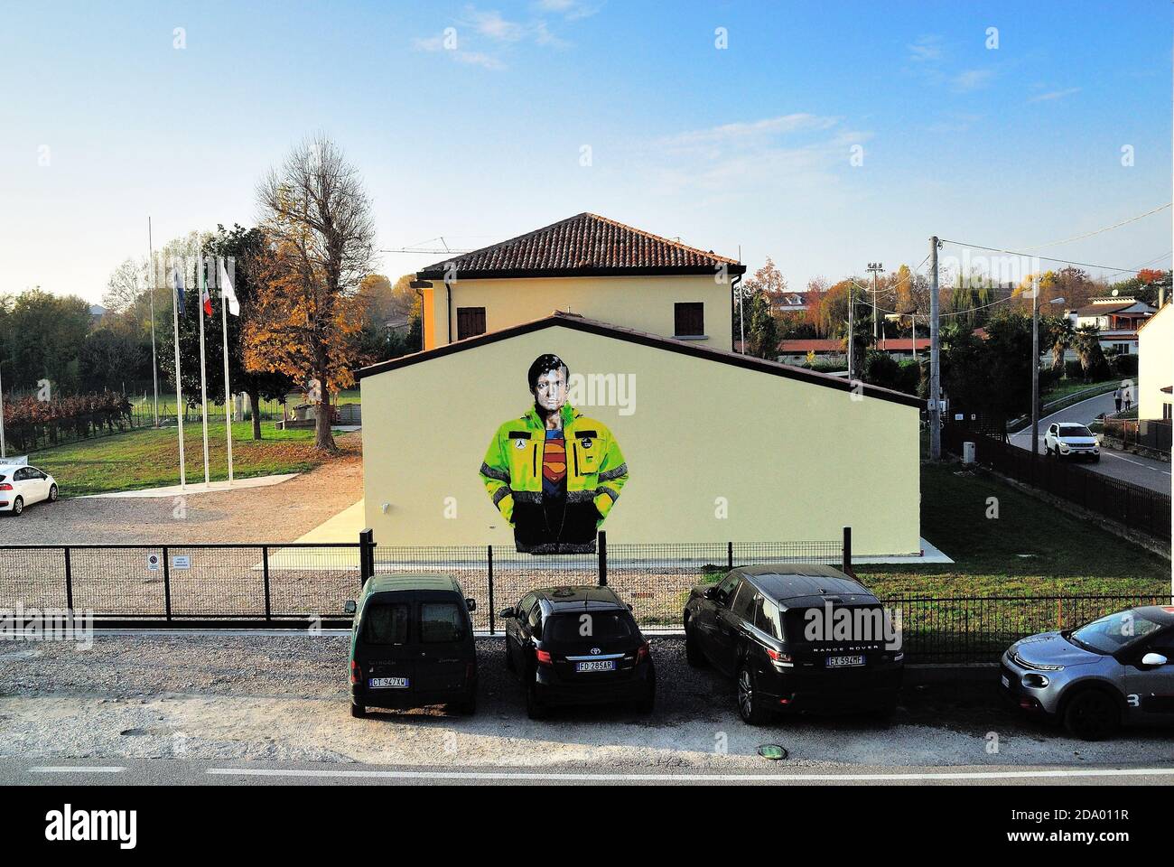 Street artist Alessio-B paints a portrait of Superman dressed in the Civil Protection uniform on a wall of the Padua Civil Protection headquarters in honor of all the volunteers who fight against covid 19. Stock Photo