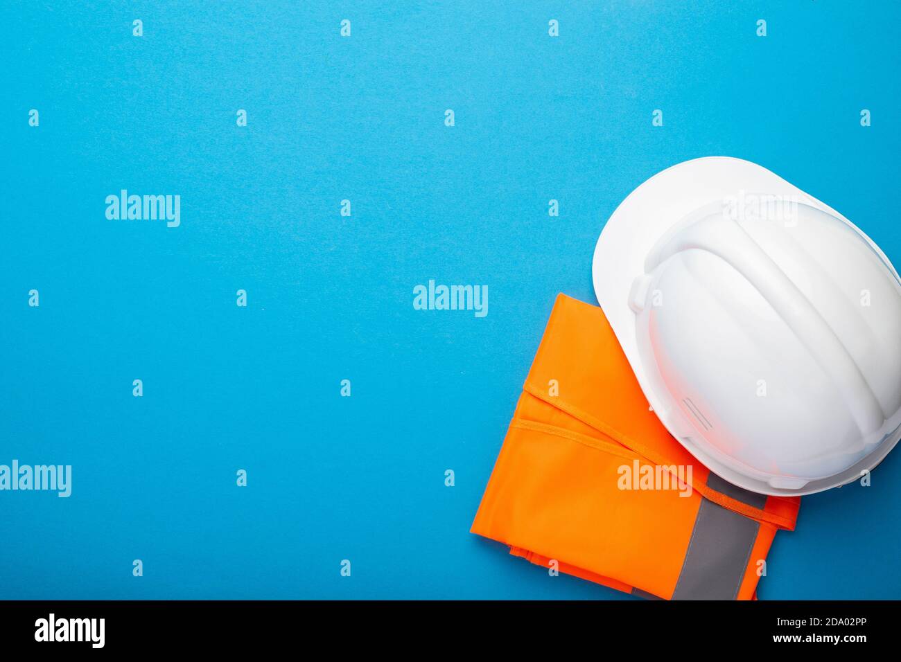Construction hat and construction vest on a blue background. Concept