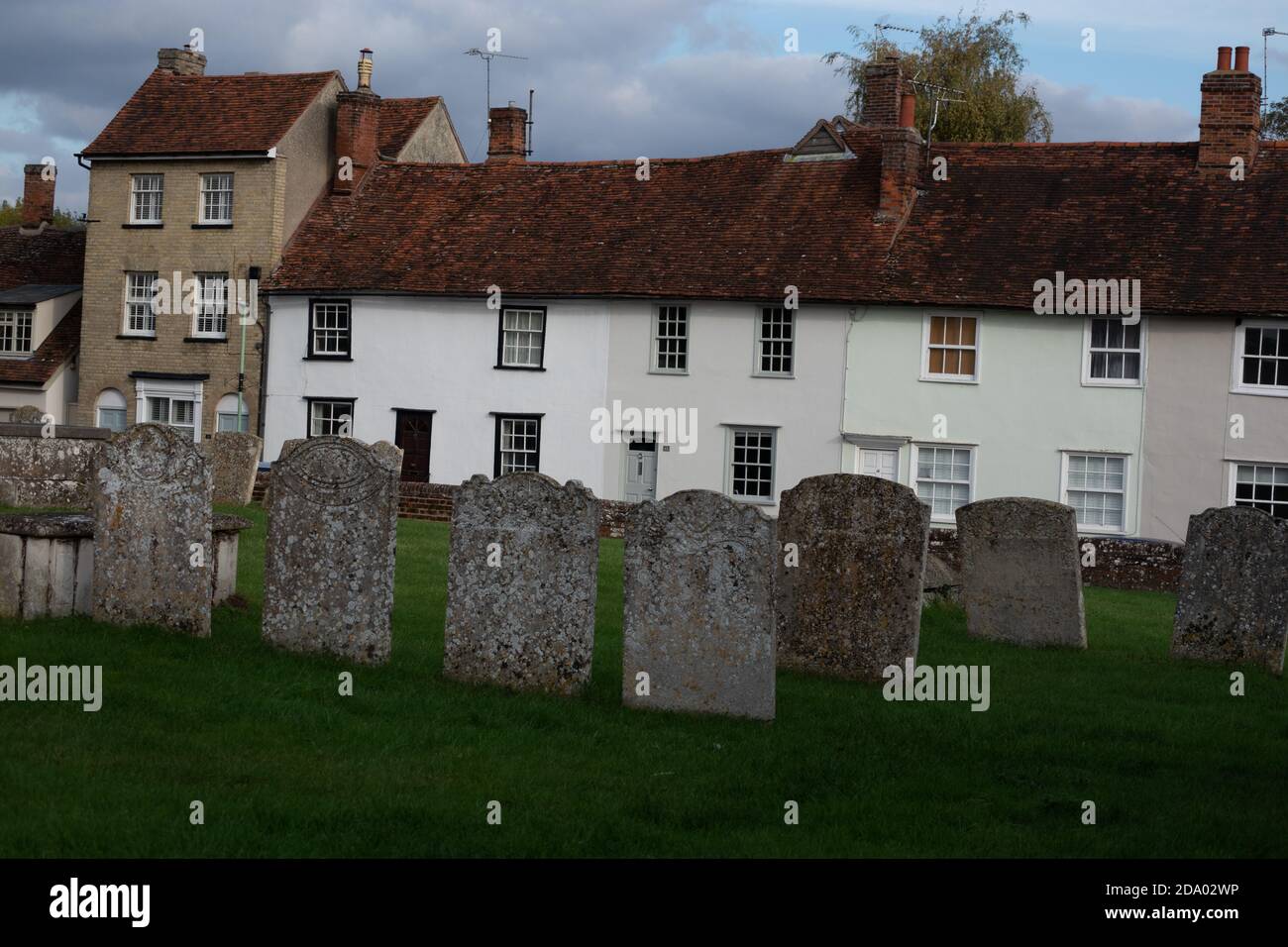 Gravestones and cottages in Clare a market town in Suffolk, England, known as old wool town of Clare Stock Photo
