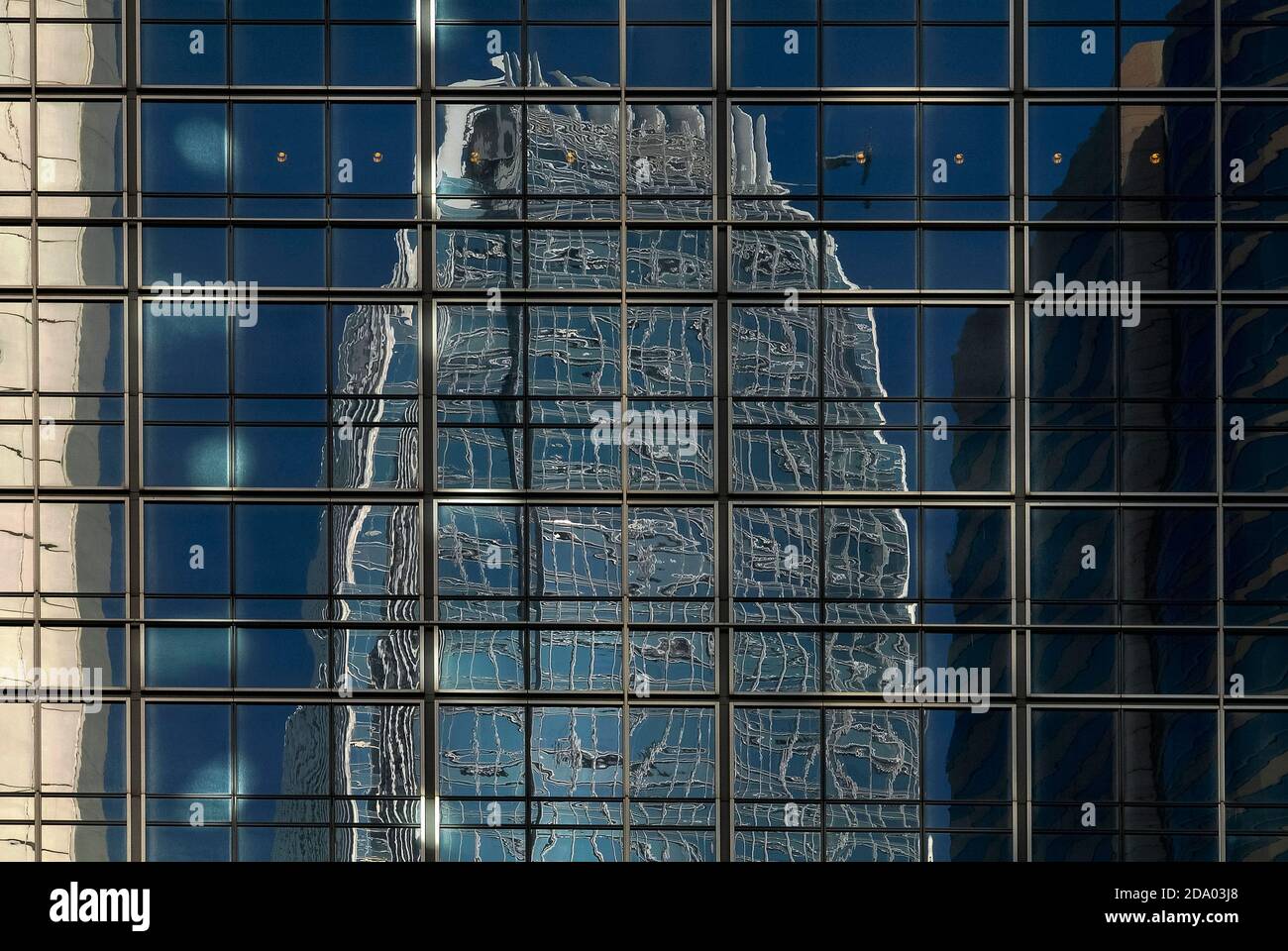 Reflective cladding on the side of the J.P. Morgan office tower in Chung Wan or Central District, Hong Kong, China, bends reality as it distorts and contorts the upper levels of one of the world’s tallest buildings, the 420m-high (1,378 ft) International Finance Centre Two (IFC2) and other high-rise buildings nearby. Stock Photo