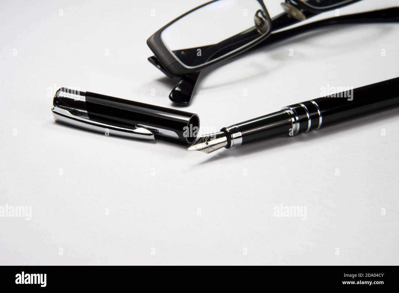 A pair of glasses and an elegant fountain pen Stock Photo
