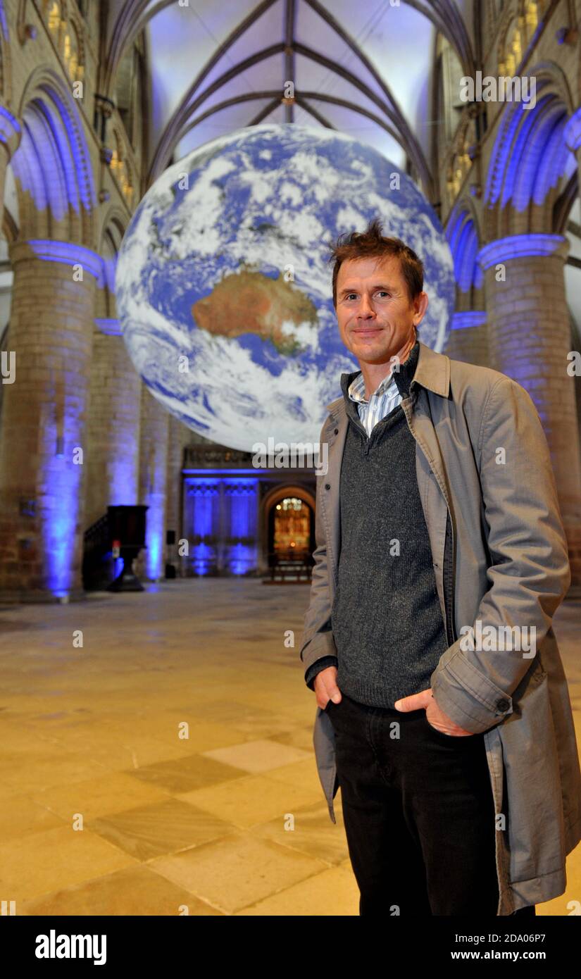 Artist Luke Jerram with his work.   He has the whole world in his hands or more specifically the whole earth in Gloucester Cathedral.    A touring art Stock Photo