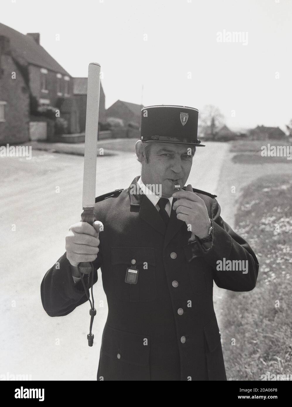 1980s, historical, a man dressed up as a french policeman blowing