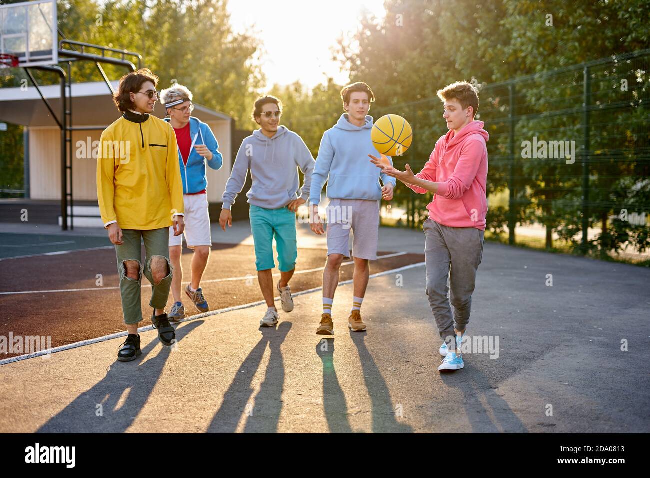 diverse young city boys are ready to play basketball together, sport club members have fun outdoors, in casual wear. portrait Stock Photo