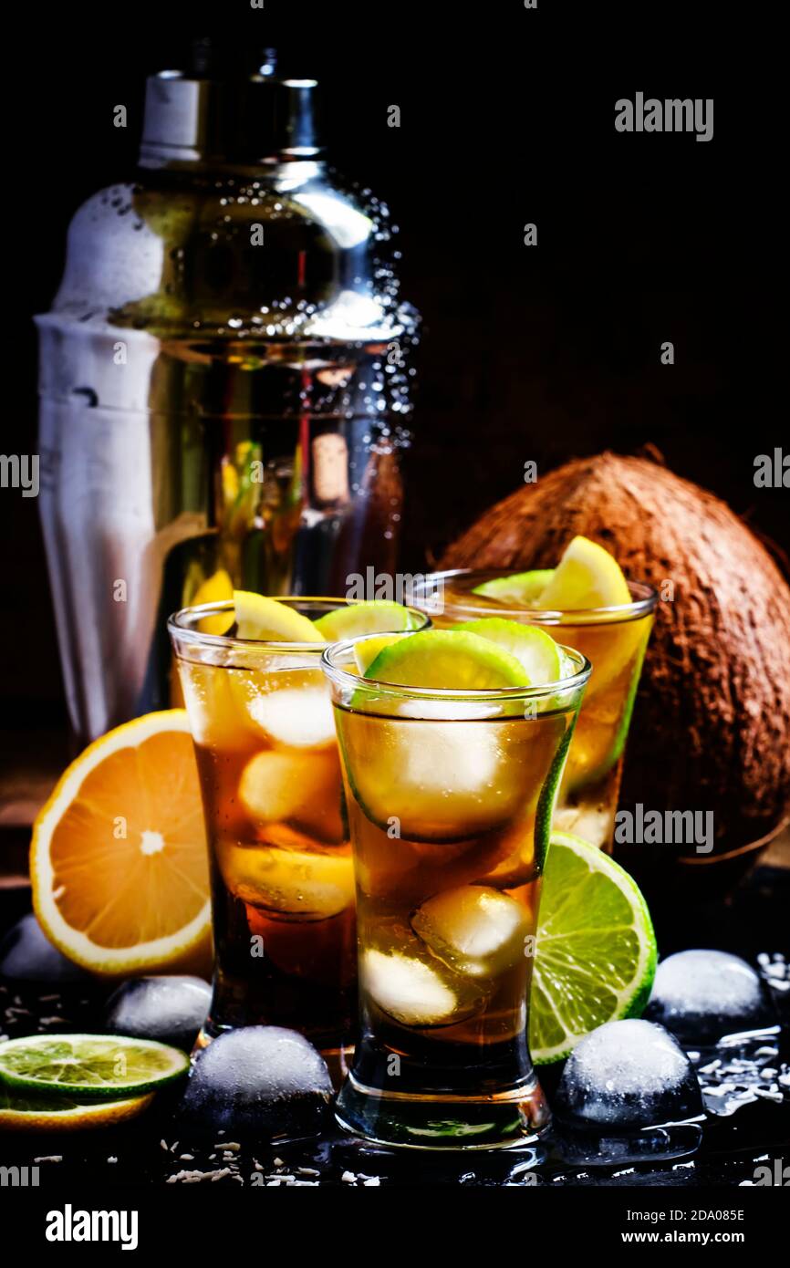 Alcoholic cocktail coconut cola, liqueur, lime, lemon and ice, black background, selective focus Stock Photo