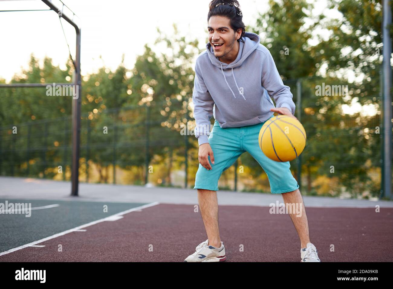 athletic young boy in casual wear keen on basketball, enjoy playing outdoors, sport concept Stock Photo
