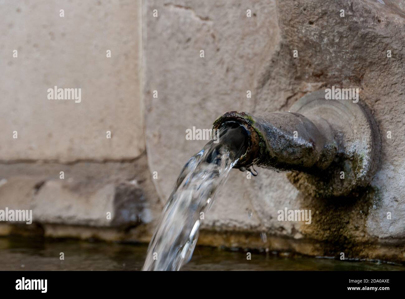 Water pouring out of an old iron spout Stock Photo Alamy
