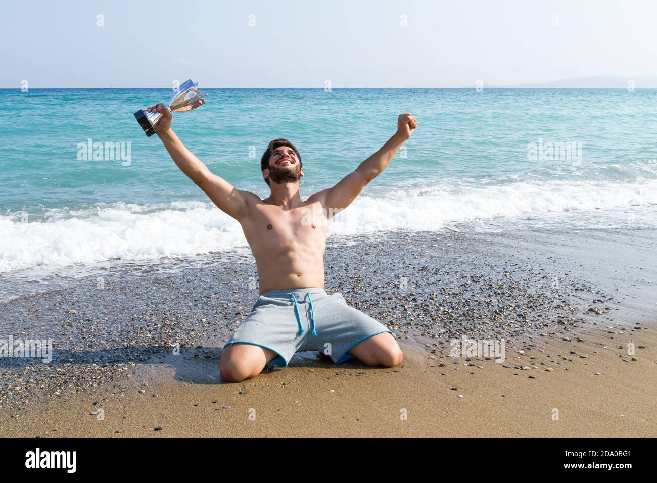 Male athlete holding up a trophy cup. Competition winner athlete
