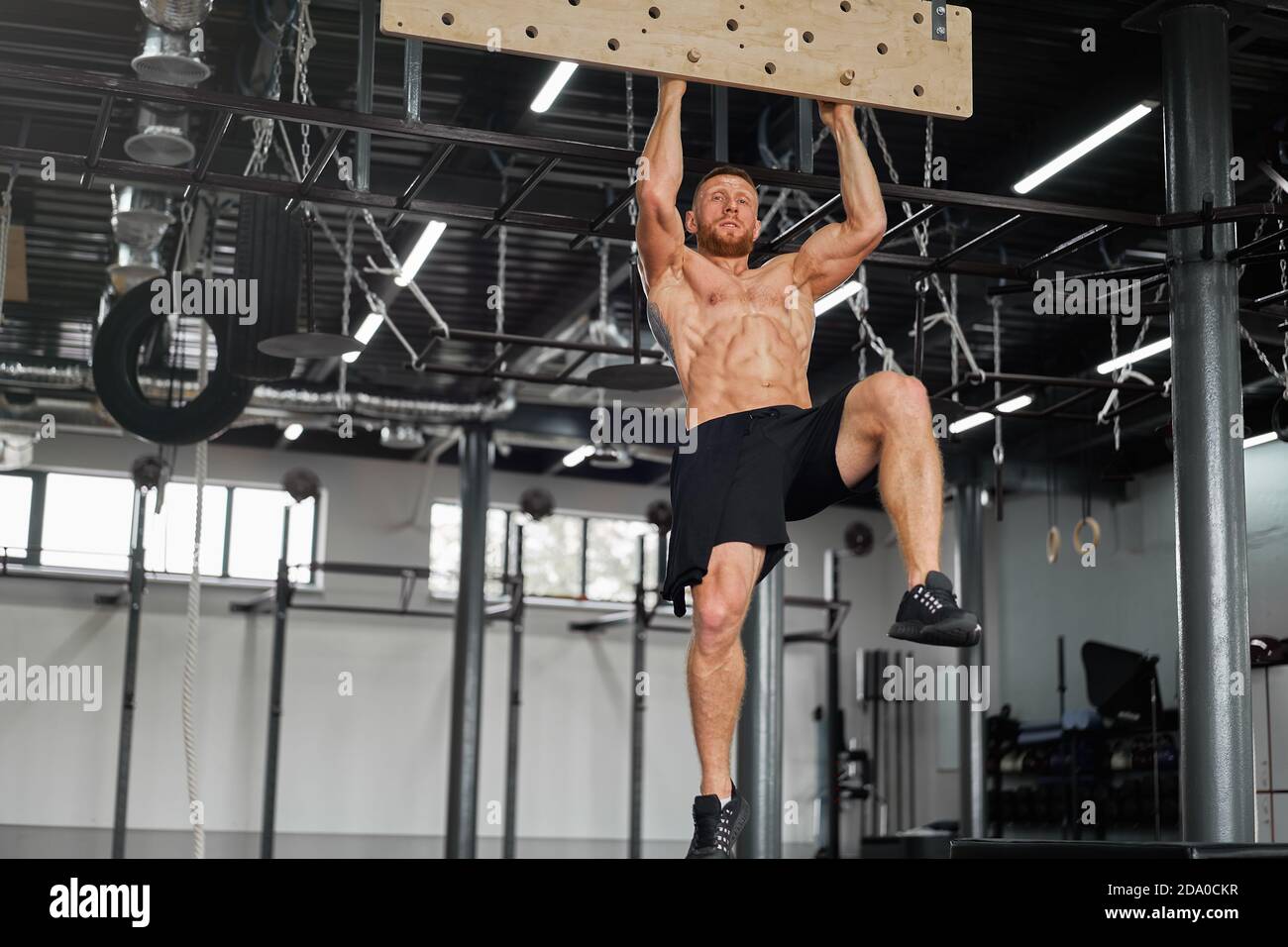 Man climbing pegboard gym athlete training arm strength stamina