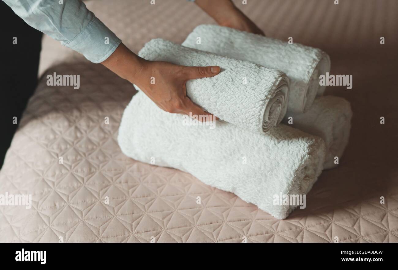 Room service. Woman changing towels in hotel room. Stock Photo