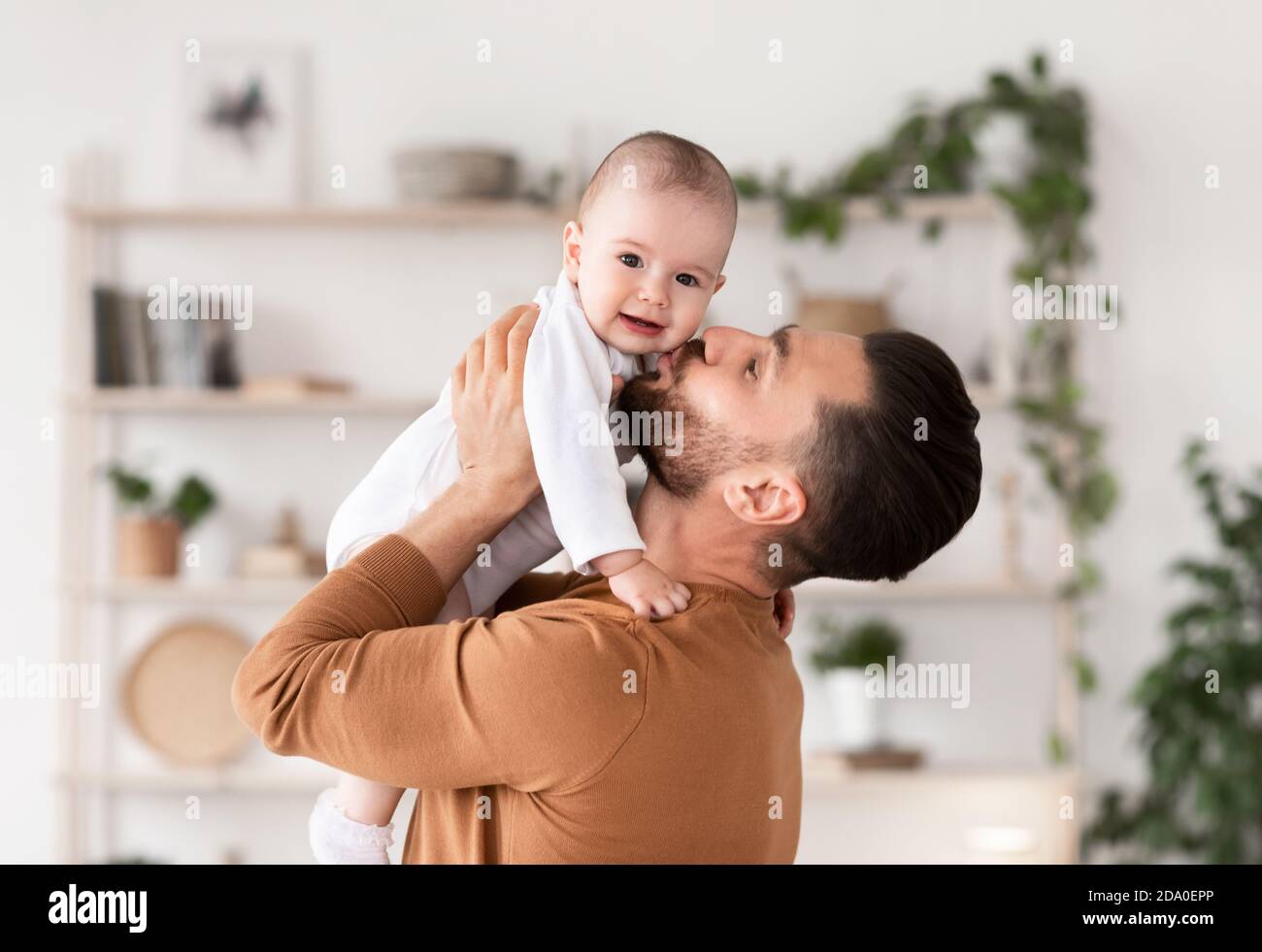 Cute Young Father Kissing His Little Baby Daughter At Home Stock Photo
