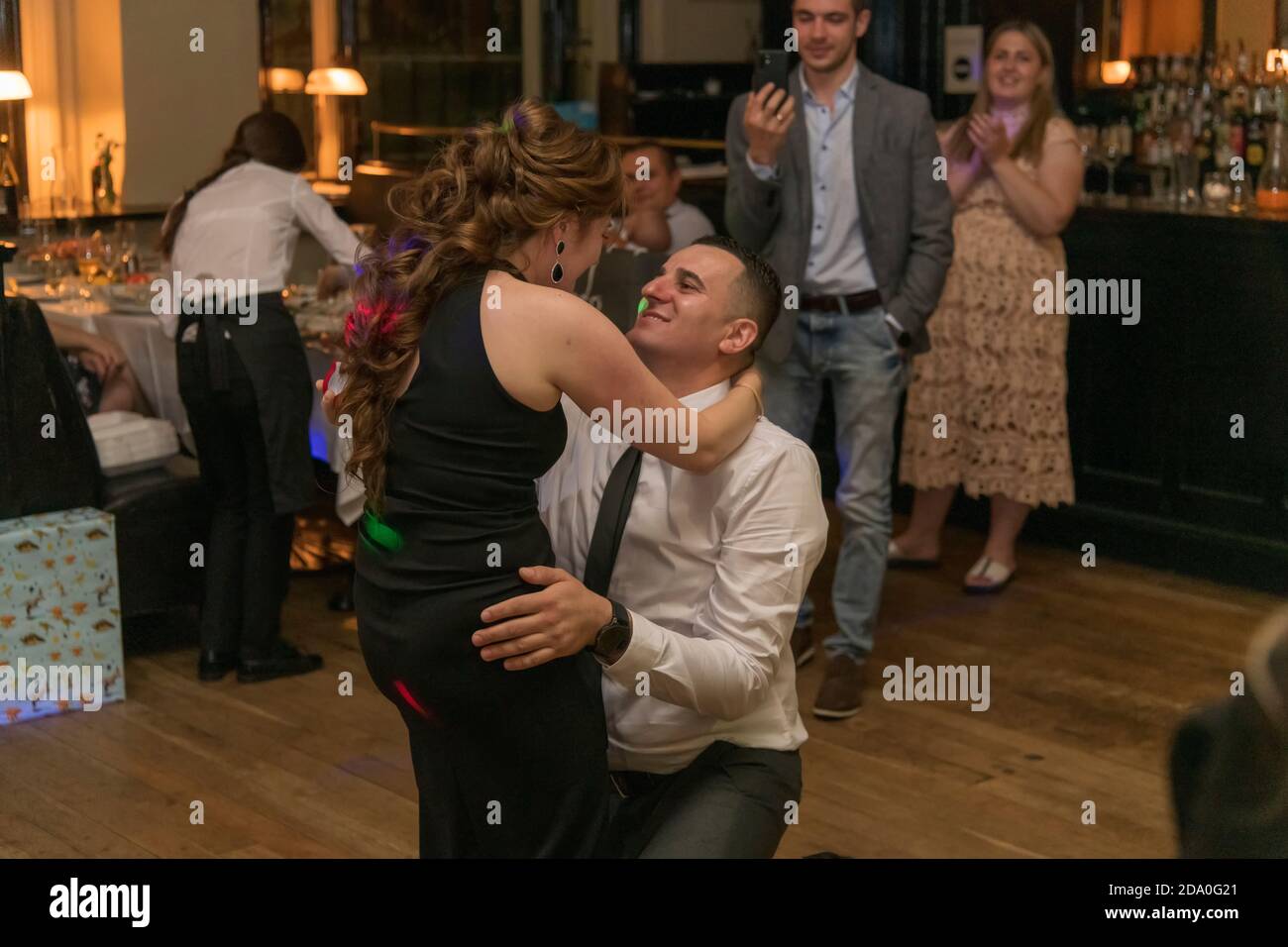 A man kneeling and proposing to a woman at the restaurant, London, UK Stock Photo