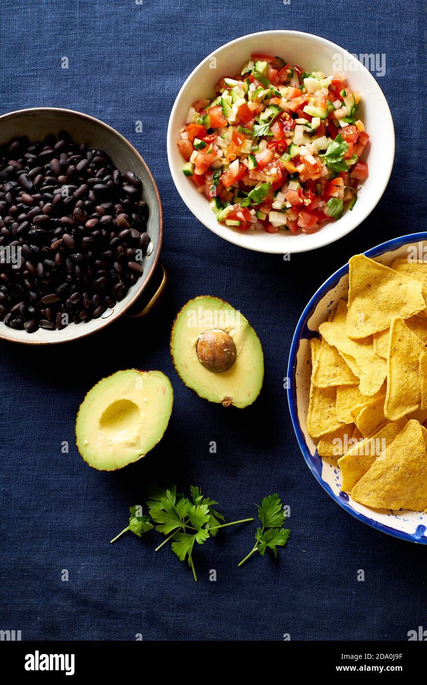 Ingredients for cooking chilaquiles - black beans, tortilla chips, corn and salsa Stock Photo