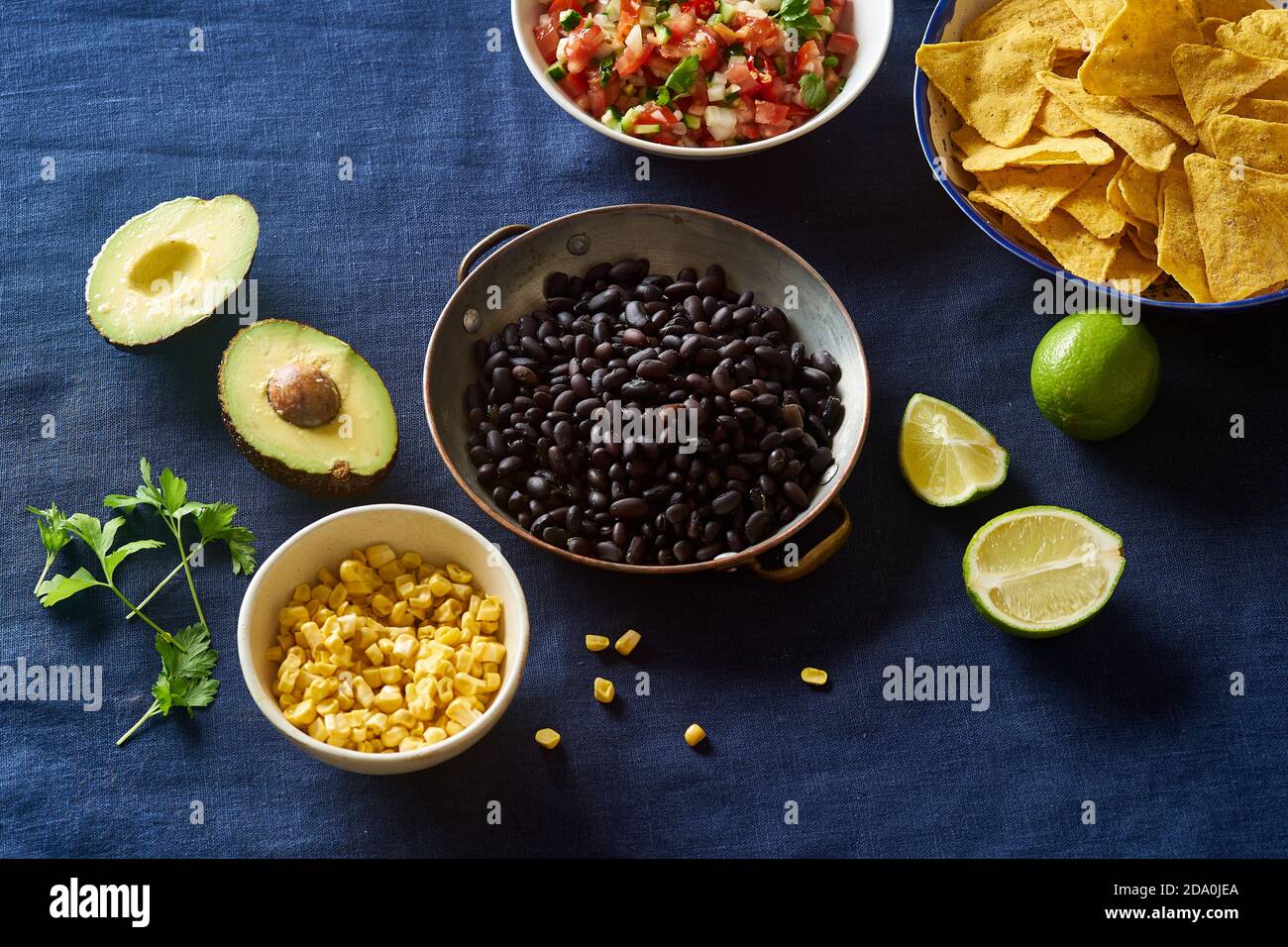 Ingredients for cooking chilaquiles black beans, tortilla chips, corn and salsa Stock Photo