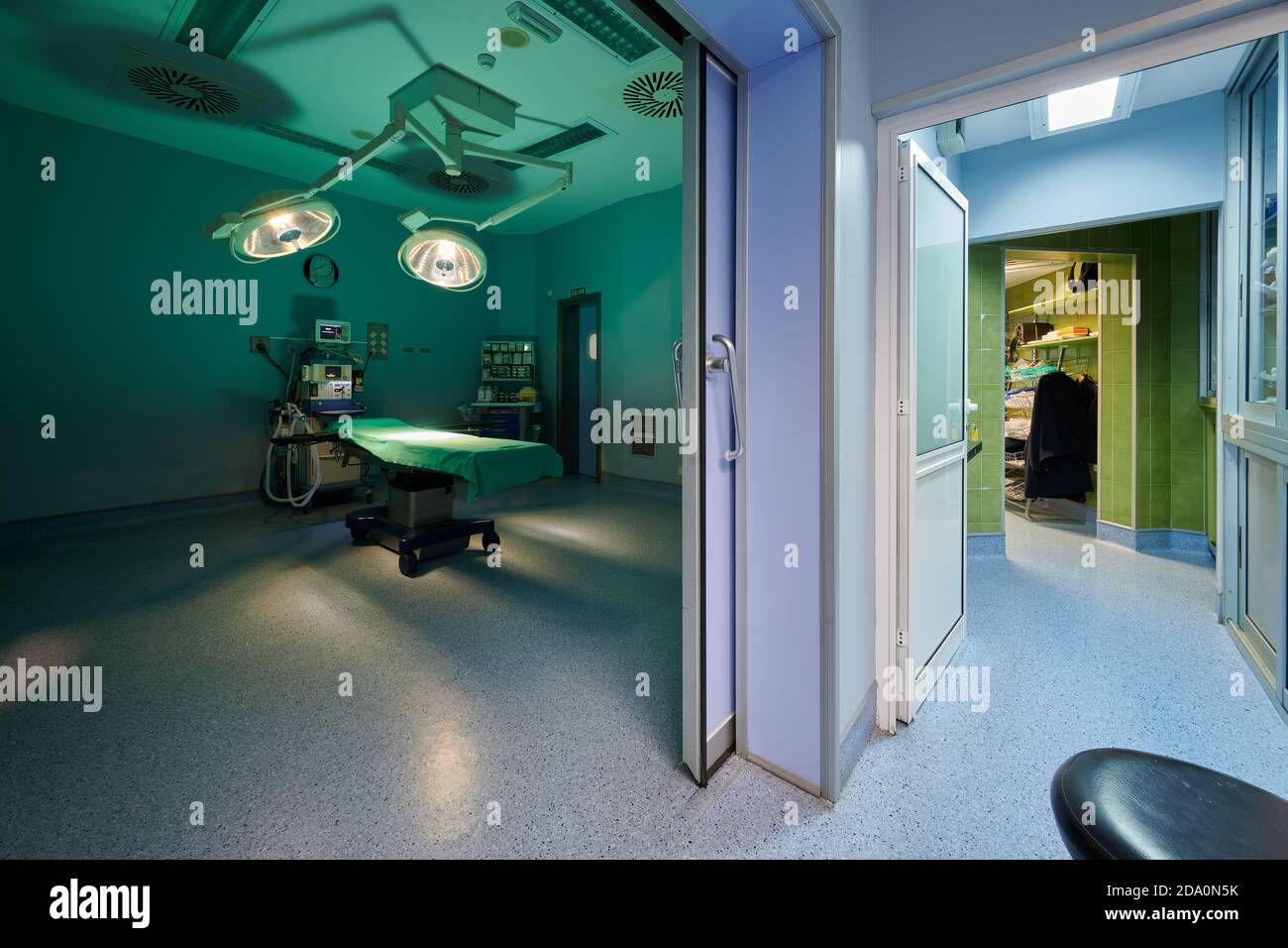 Contemporary operating room interior with couch under shiny lamps near professional devices in
