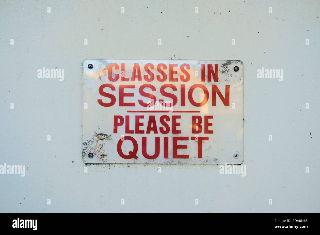 Clear transparent plastic sign with red letters warning that classes are in session, please be quiet; City College of San Francisco, California. Stock Photo