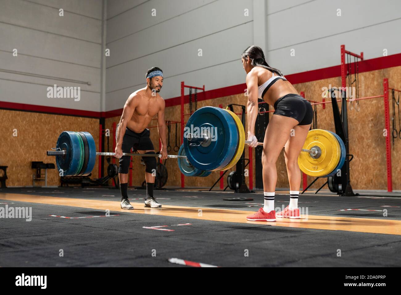 Muscular sportsman and sportsWoman lifting heavy barbells and making
