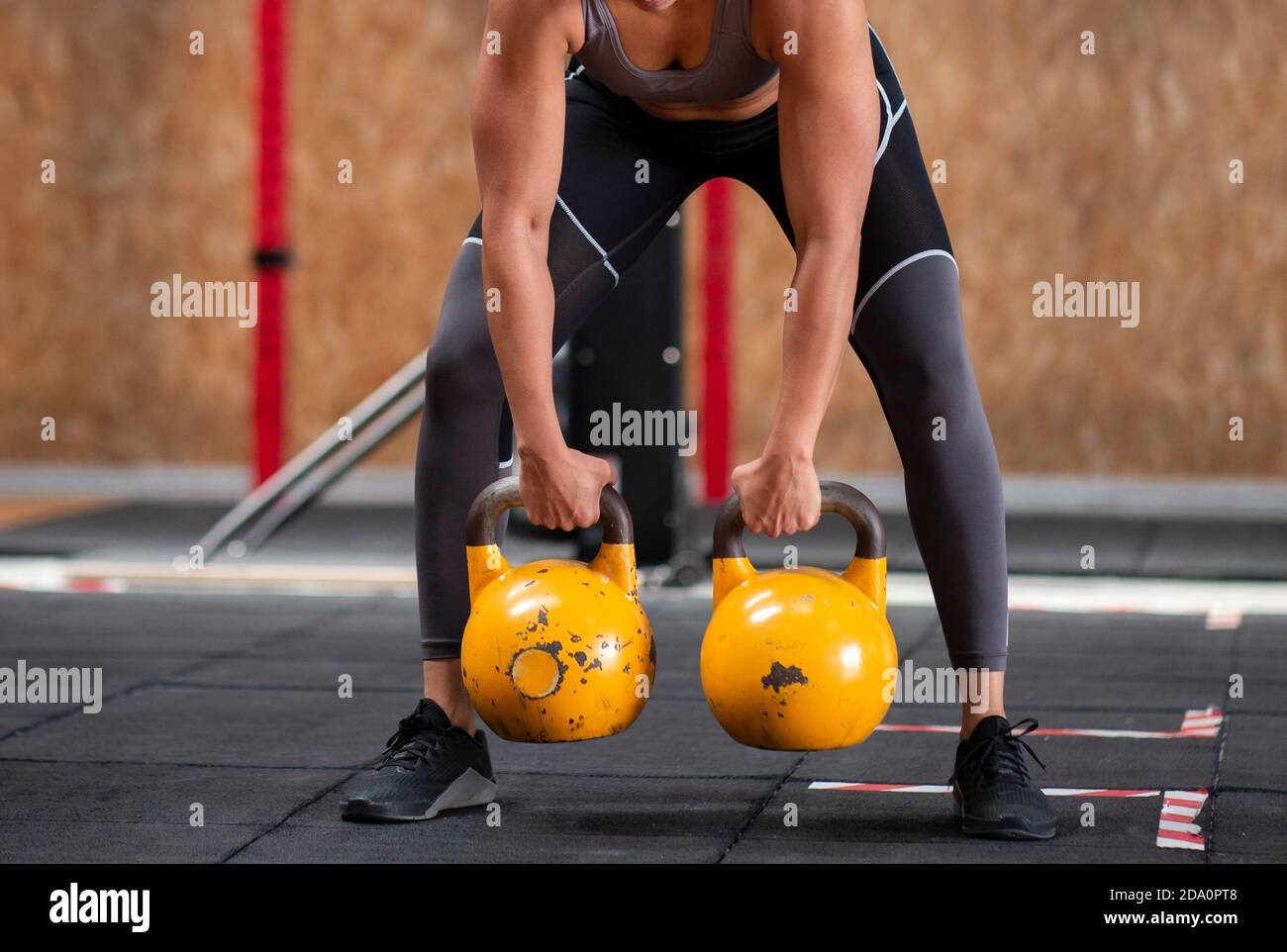 Young fitness female exercise with kettle bell. Caucasian woman doing  crossfit workout at gym. Stock Photo