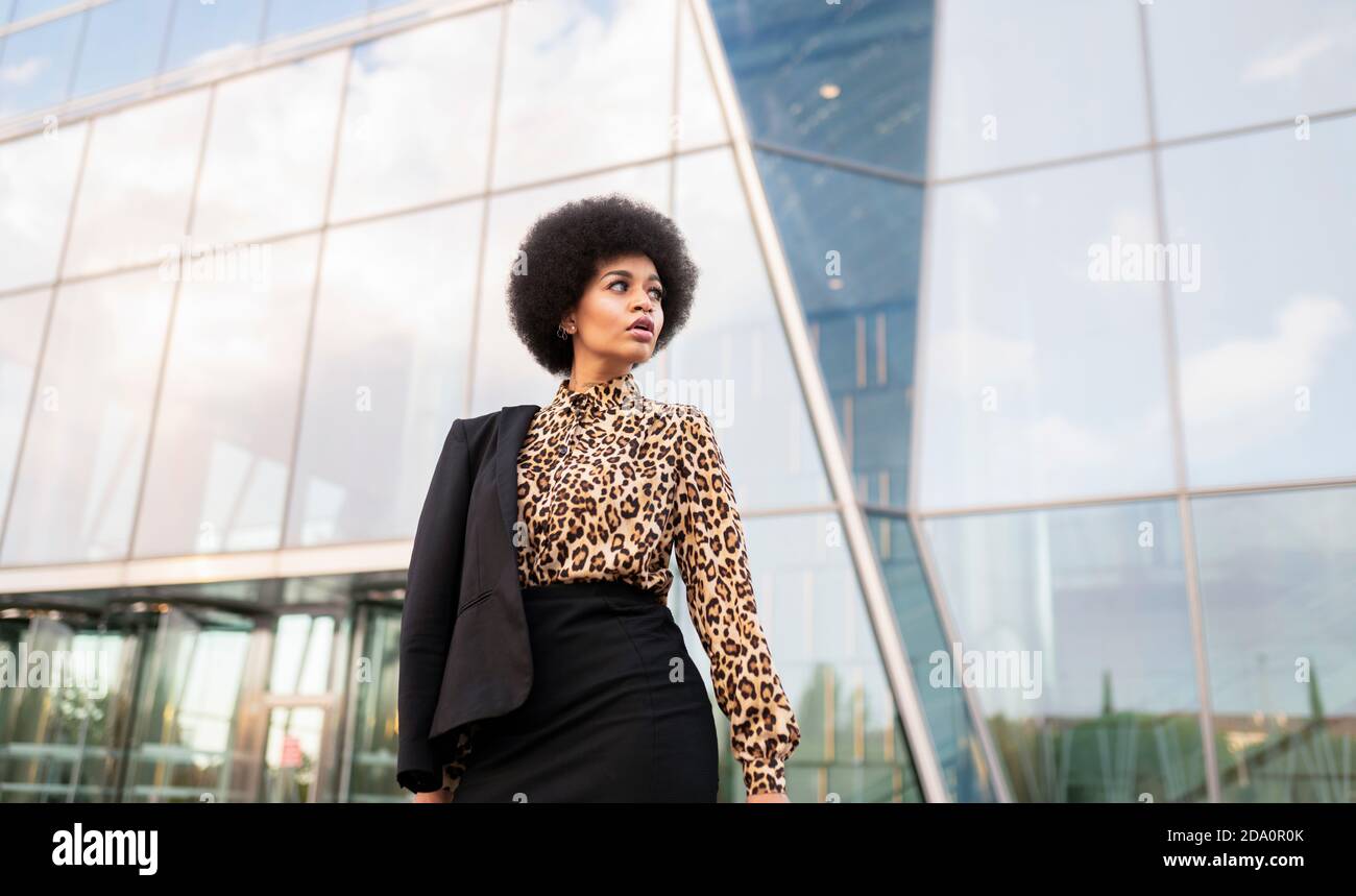 From below of confident African American female in formal wear standing ...