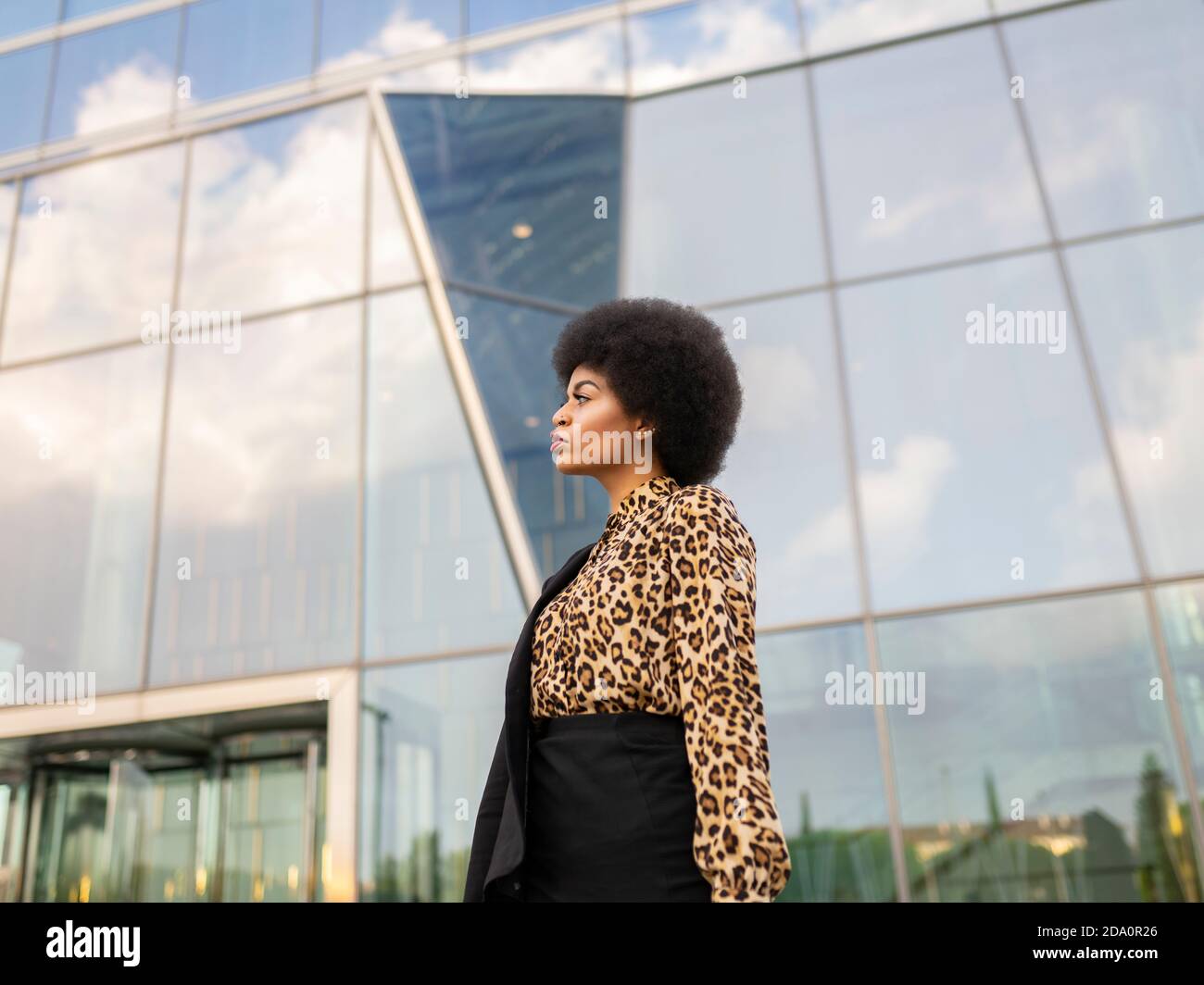 Confident African American female in formal wear standing near modern ...