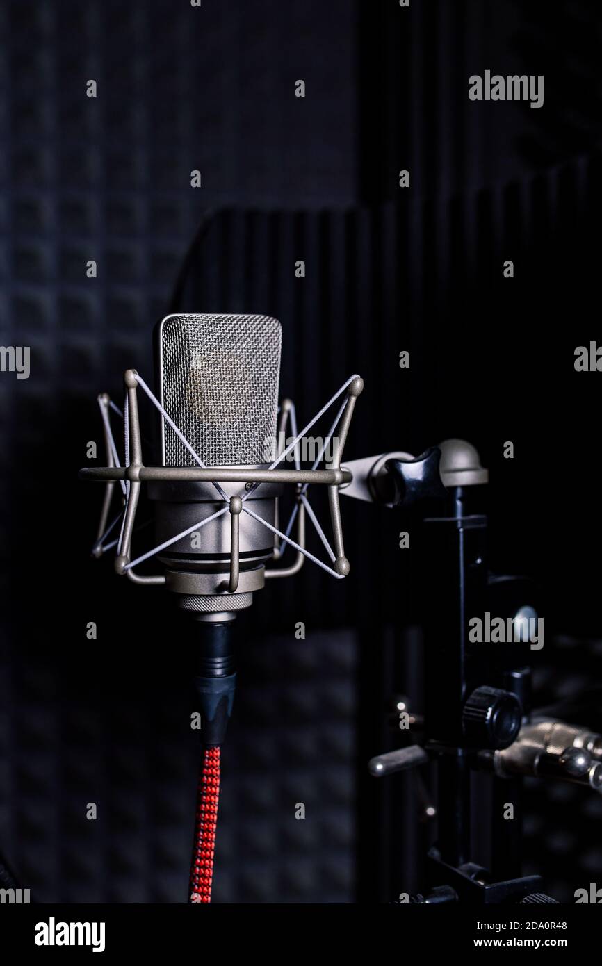 Contemporary metal microphone with wire placed on background of soundproof  foam with pyramid shaped pattern in dark music recording studio Stock Photo  - Alamy