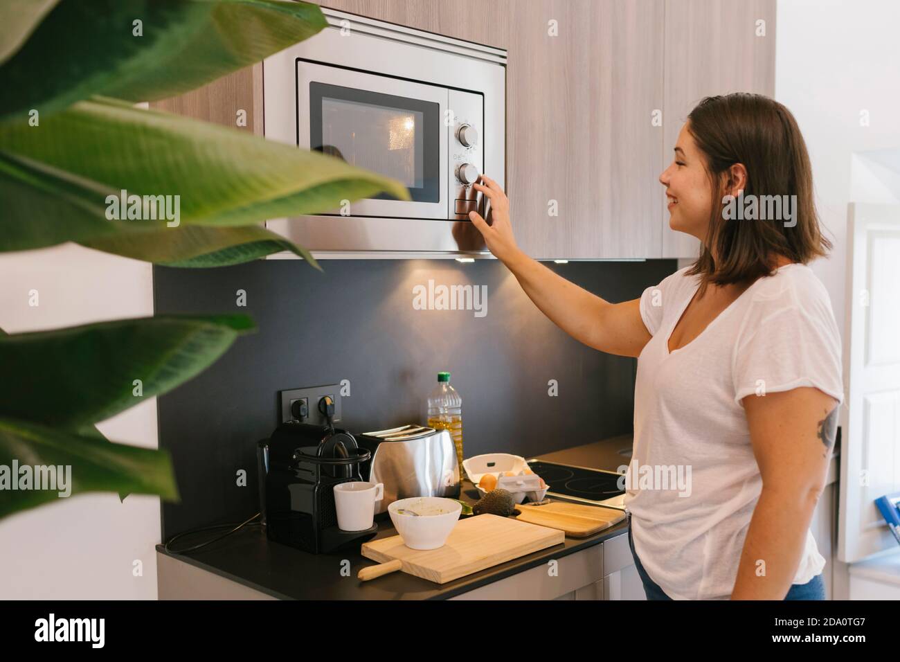 https://c8.alamy.com/comp/2DA0TG7/woman-using-a-microwave-for-cooking-some-poached-eggs-2DA0TG7.jpg