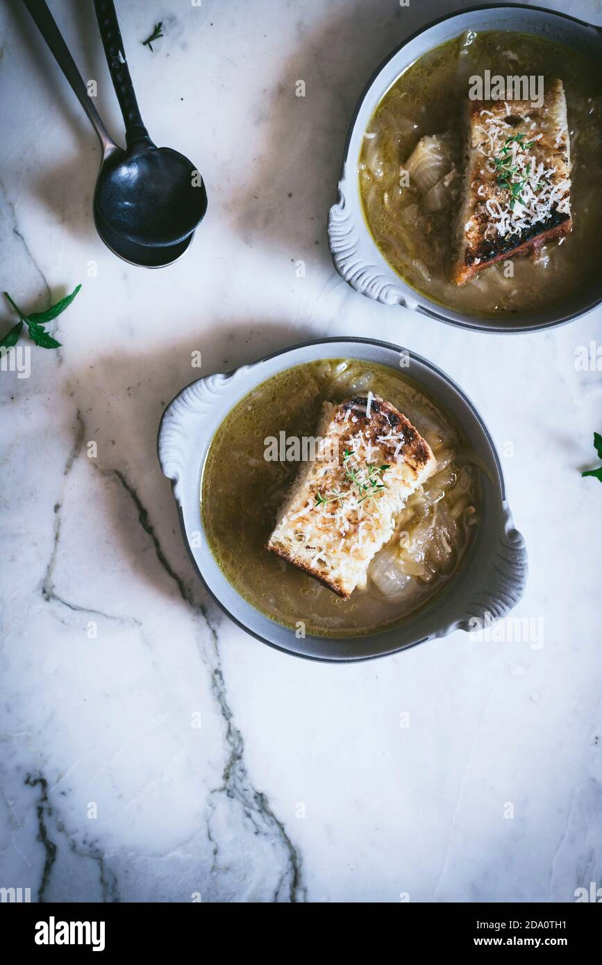 From above bowl with palatable French onion soup near towel on marble surface Stock Photo