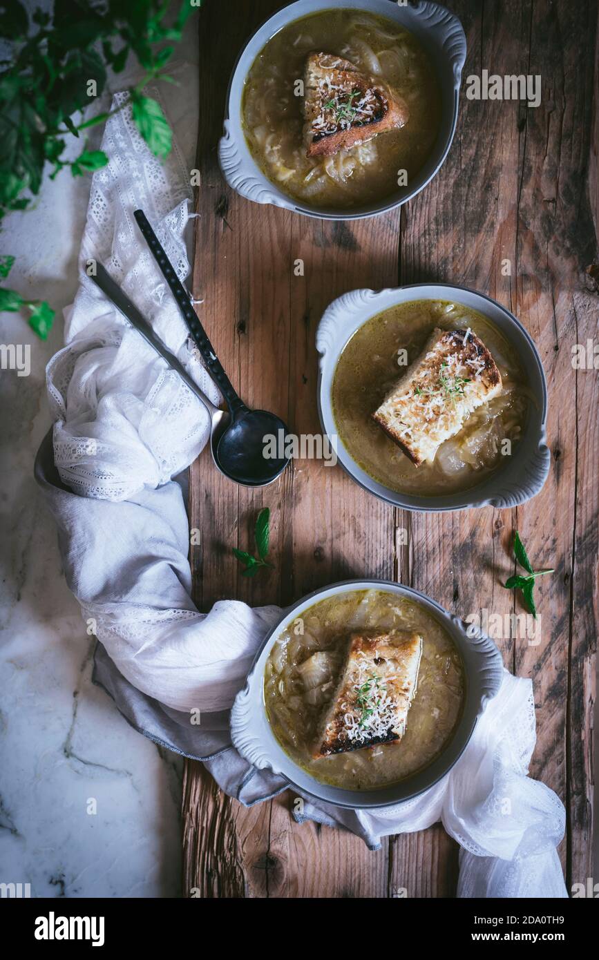 From above bowl with palatable French onion soup near towel on wooden surface Stock Photo