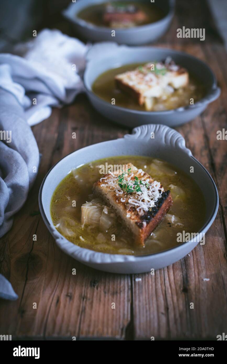 From above bowl with palatable French onion soup near towel on wooden surface Stock Photo