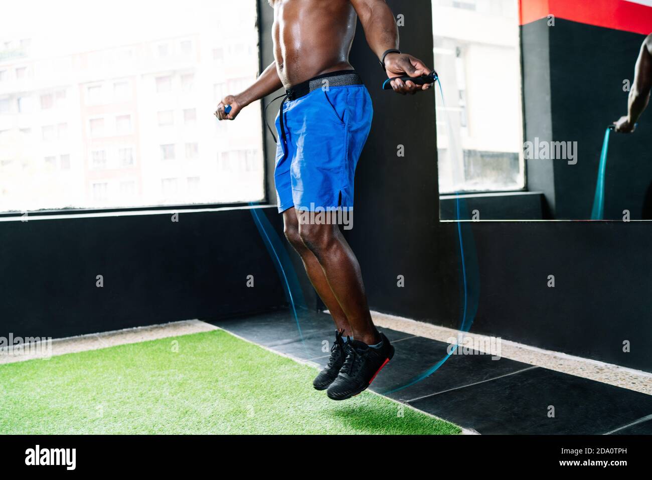 Sweatyatt Ropes Sweaty African American sportsman with muscular body skipping rope in ...