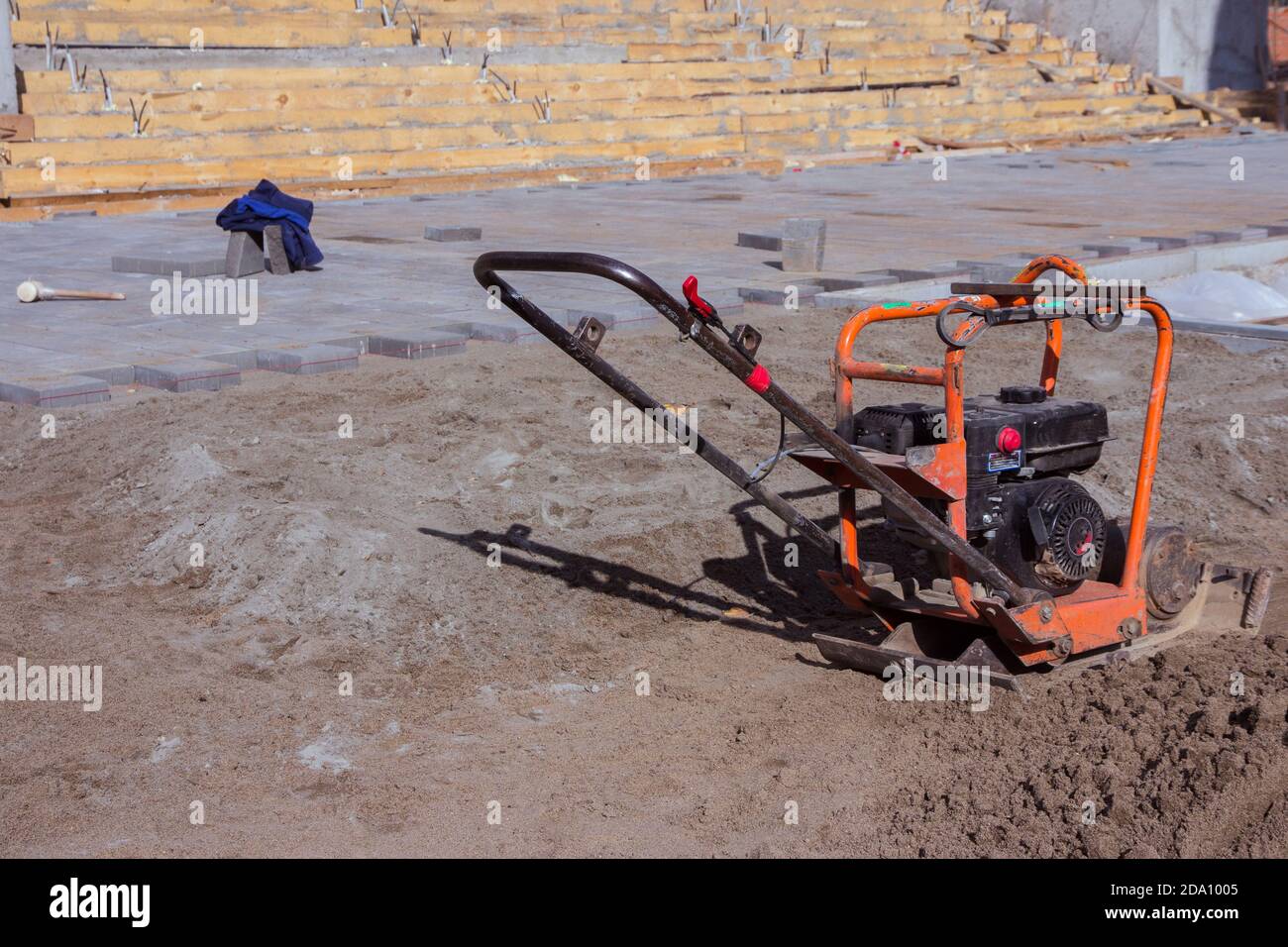 Vibrating plate compactor machine at a construction site. Equipment for