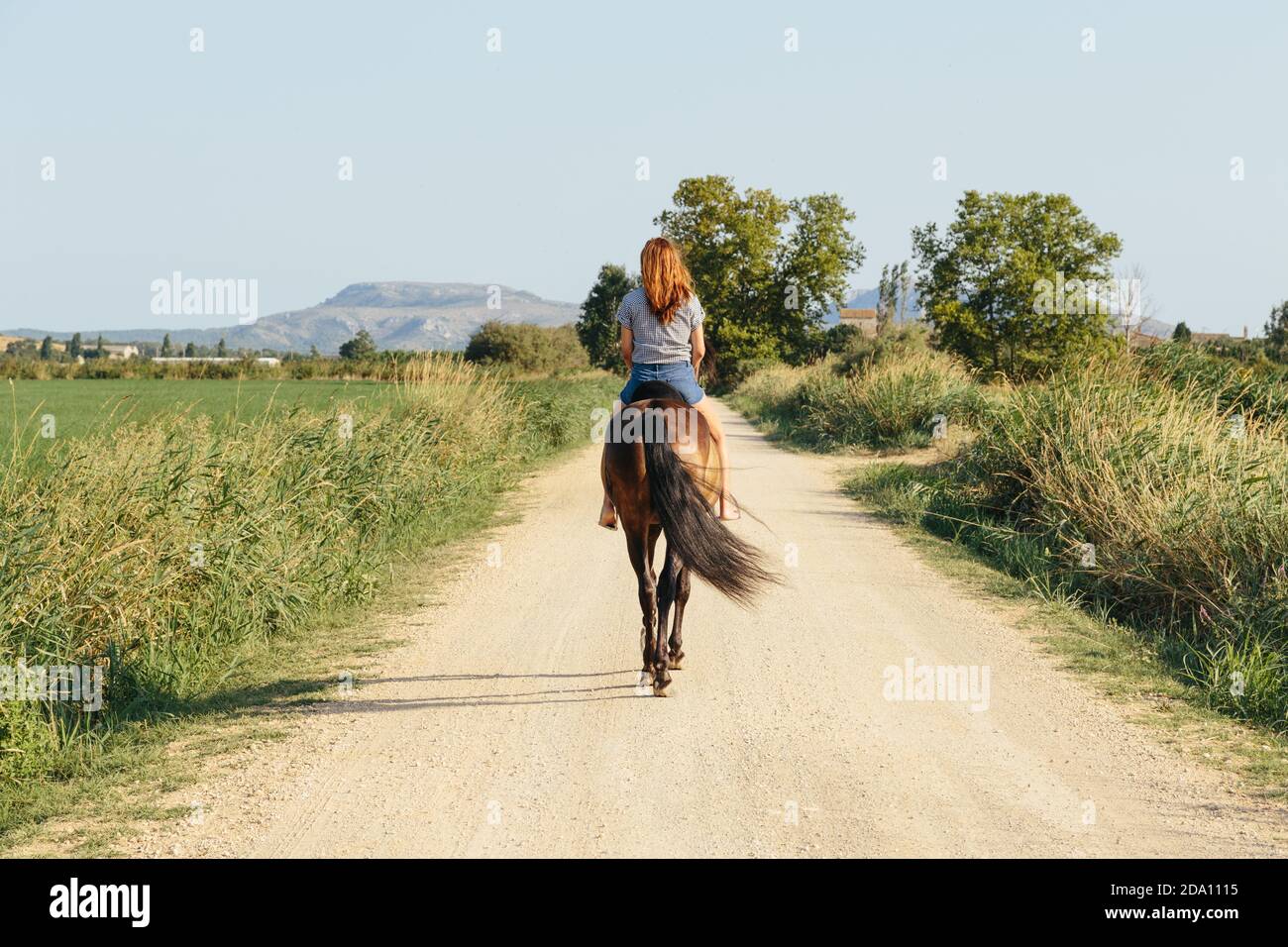 Beautiful Rod Riding Beautiful Woman riding along a country road on a sunny afternoon Stock ...