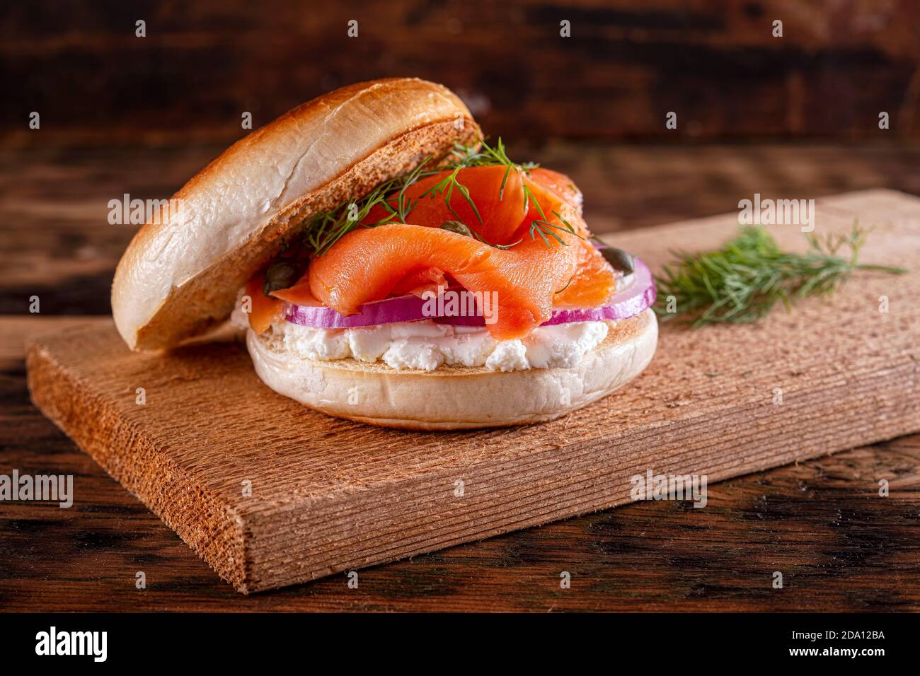 A delicious toasted plain bagel with smoked salmon, cream cheese, red onion, capers and dill. Stock Photo
