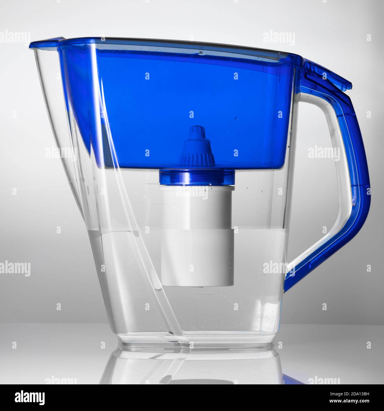 Studio shot of a plastic water filter jug standing on the reflecting surface Stock Photo