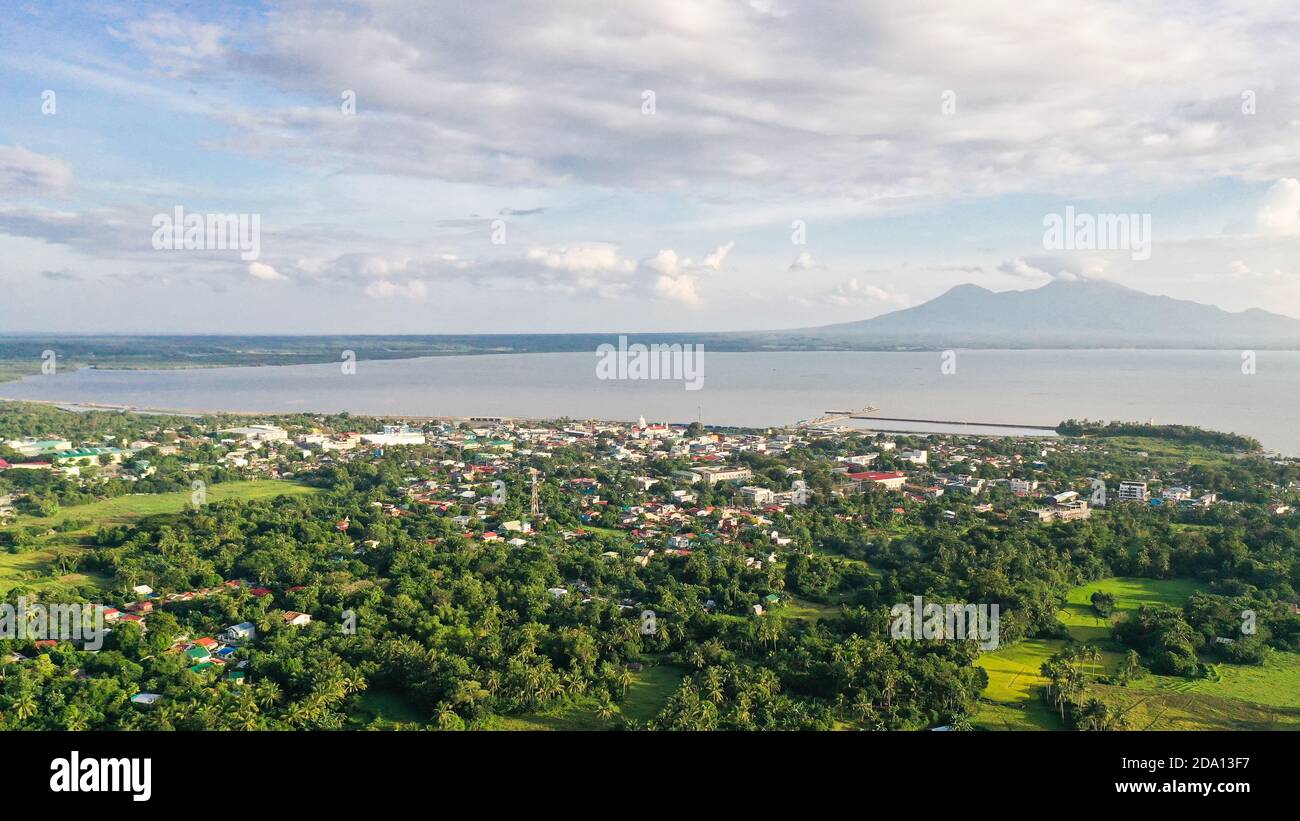View of a small town and a volcano in the distance. Sorsogon City, Luzon, Philippines. Asian town by the sea, top view. Stock Photo