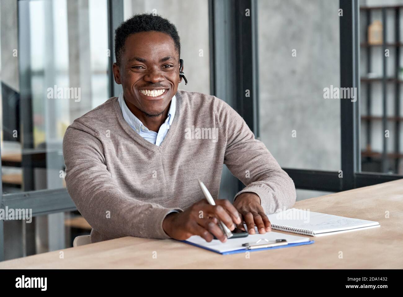 Cheerful african business man wearing headset laughing looking at camera. Stock Photo