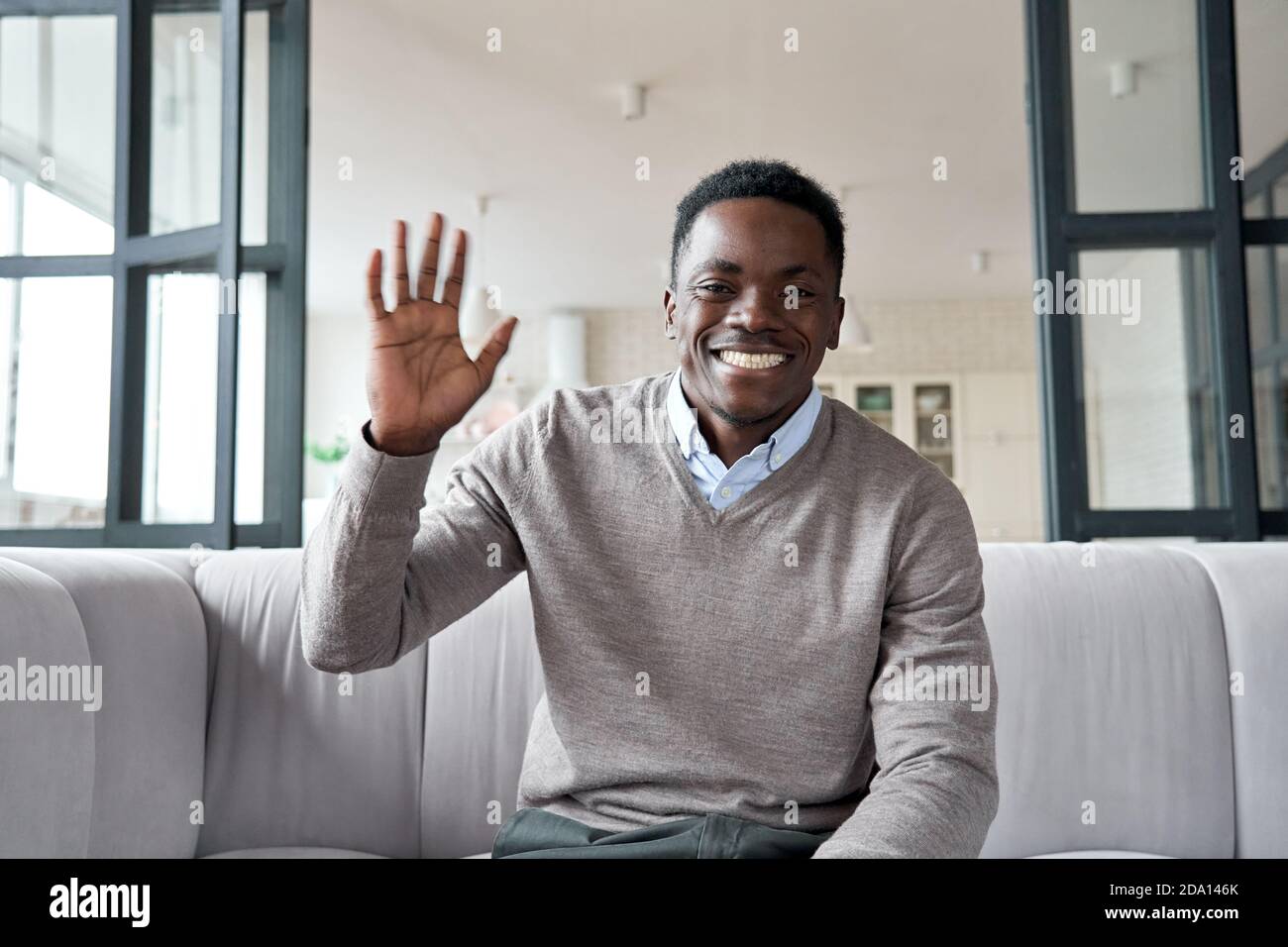 Happy african young man waving hand looking at camera video conference calling. Stock Photo