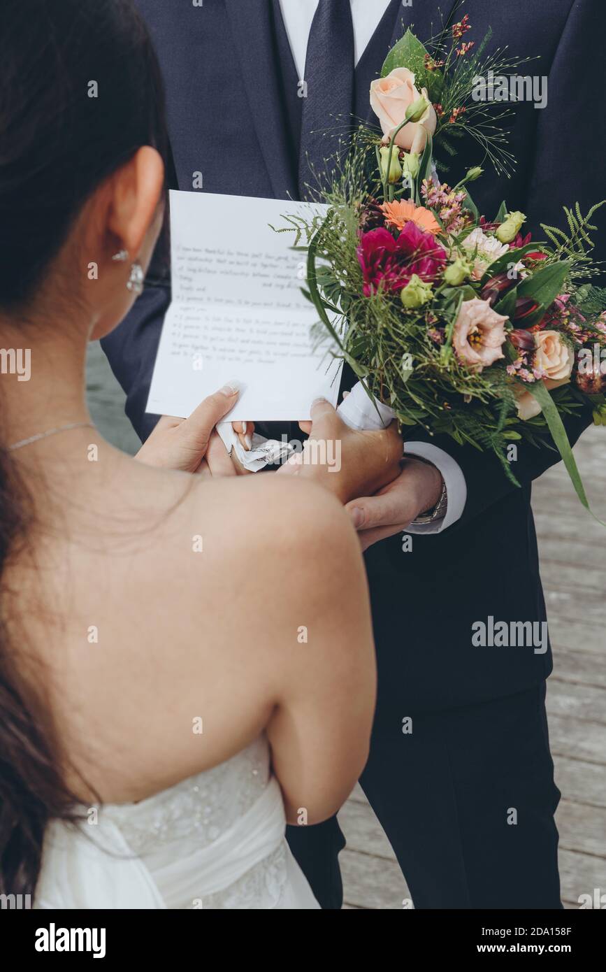 Bride reading her vows to the groom while official marriage ceremony. Wedding agency concept. Stock Photo