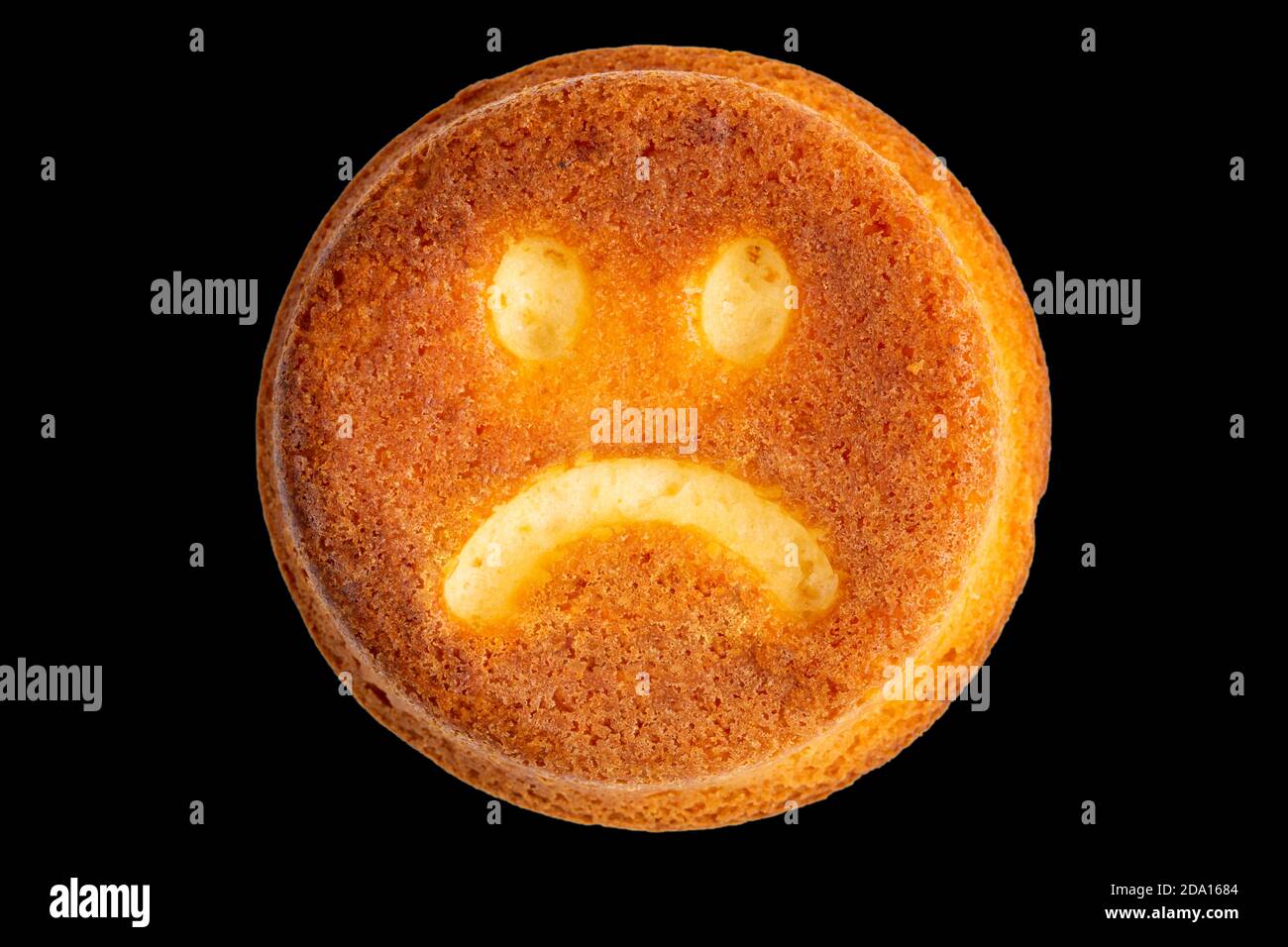 unhappy face biscuit cookie isolated on black in flat lay perspective Stock Photo