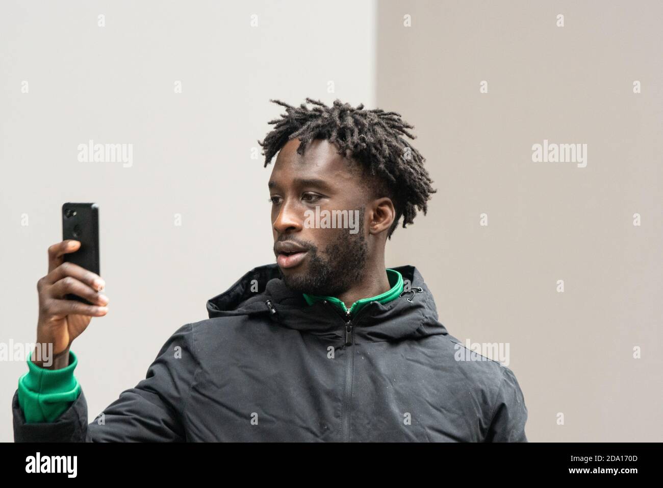 young man with dreadlocks holding smartphone during street protest Manchester 08-11-2020, anti lockdown protest lockdown2 covid covid19 Stock Photo
