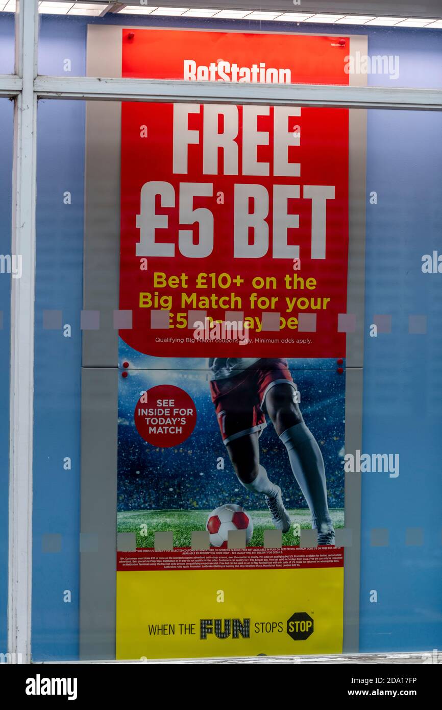 a poster advertising betting and gambling in the window of a high street bookmakers shop selling the benefits of an an addictive costly addiction. Stock Photo