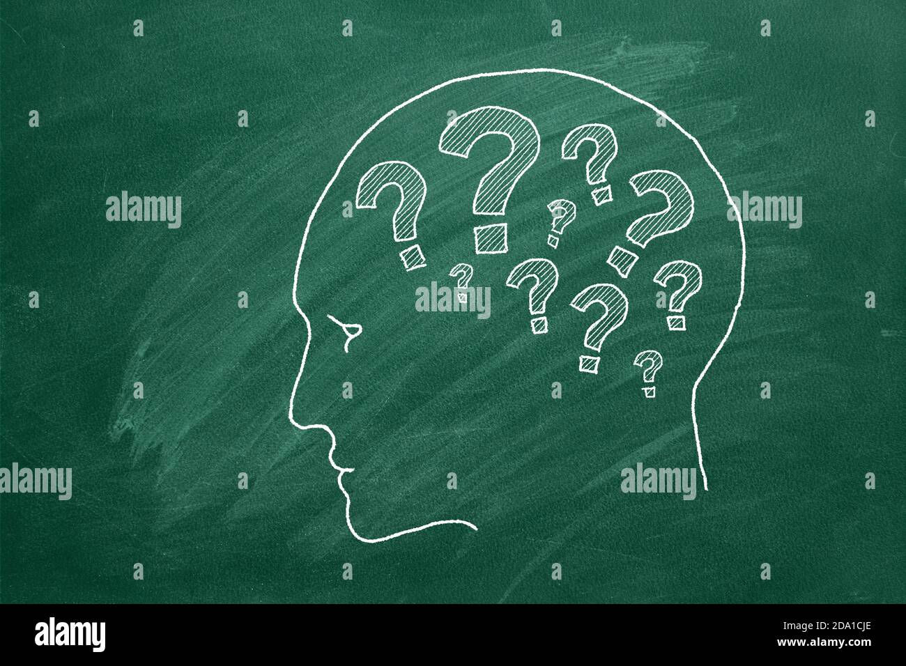 Human head with question marks inside. Animated illustration on green chalkboard. Stock Photo