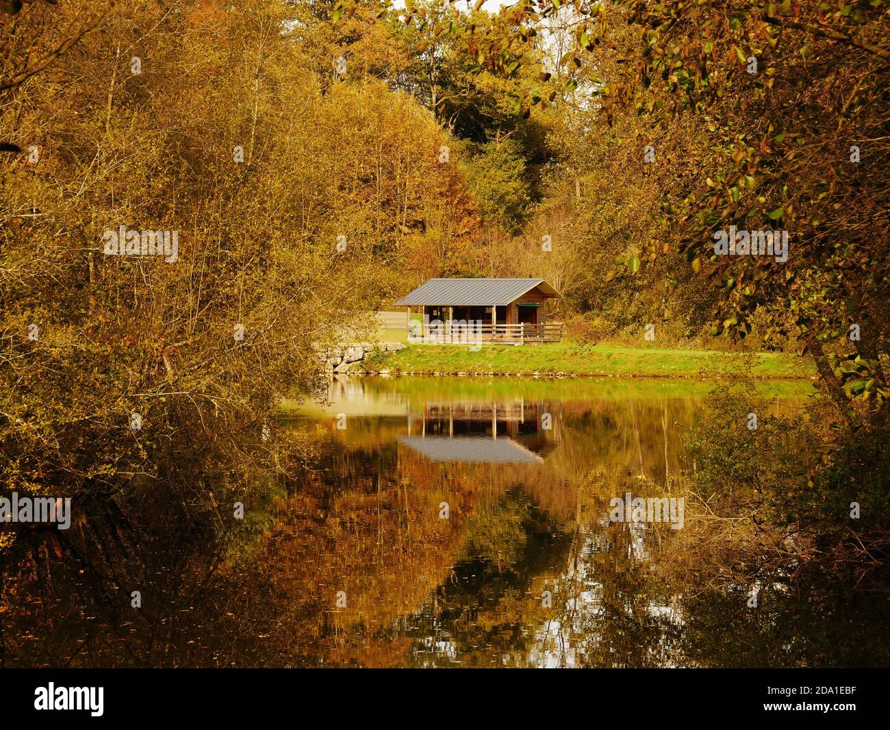 Forest lake in the south of France, during the autumn season with a view of a chalet Stock Photo